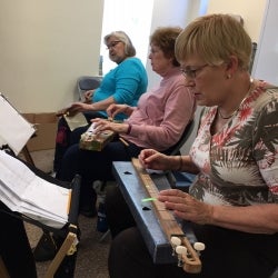 Image of 3 ladies playing musical instruments during a LLP class