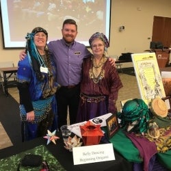 Image of Lifelong Learning Program Coordinator, Andrew Ross, posing with 2 Belly Dancing participants